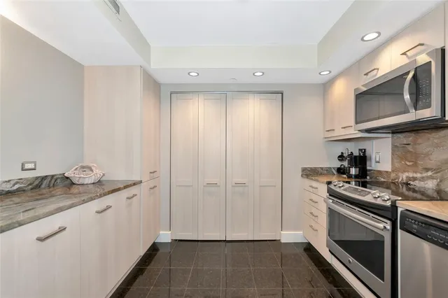 a kitchen with stainless steel appliances granite countertop a sink and a stove