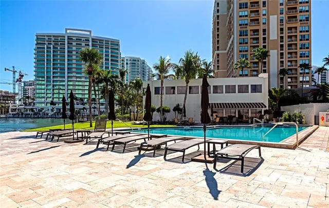 a view of swimming pool with lawn chairs and potted plants