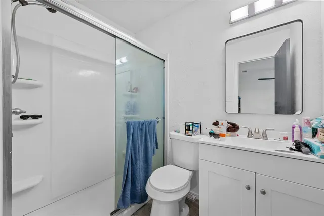 a bathroom with a toilet sink vanity and mirror