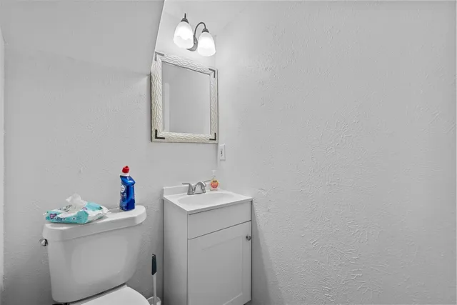 a bathroom with a sink mirror vanity and toilet