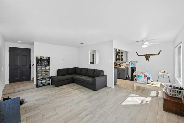 a living room with furniture and a wooden floor