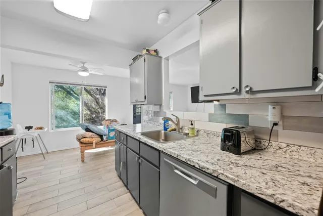 a kitchen with counter top space cabinets and living room view