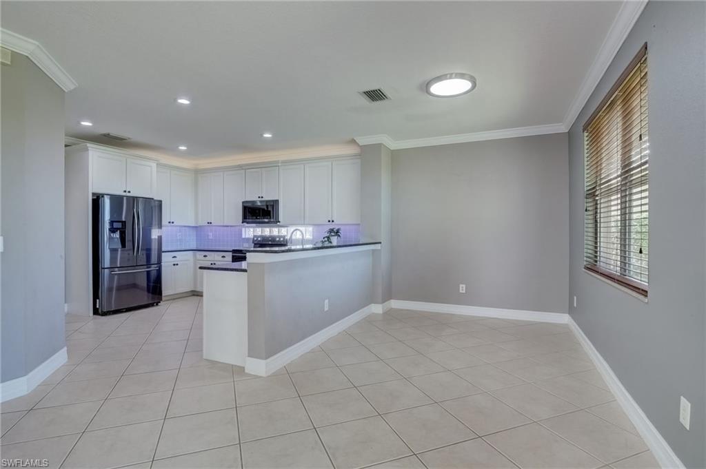 1654 Double Eagle Trail Naples, FL 34120 - Photo 2 of 48 Kitchen with stainless steel appliances, kitchen peninsula, and white cabinets