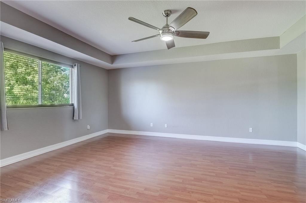 1654 Double Eagle Trail Naples, FL 34120 - Photo 25 of 48 Master bedroom with ceiling fan, a raised ceiling, and light wood-type flooring