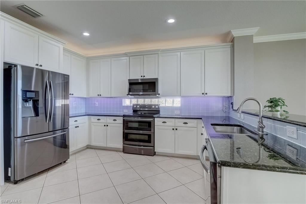 1654 Double Eagle Trail Naples, FL 34120 - Photo 5 of 48 Kitchen with white cabinetry, stainless steel appliances, sink, and dark stone counters