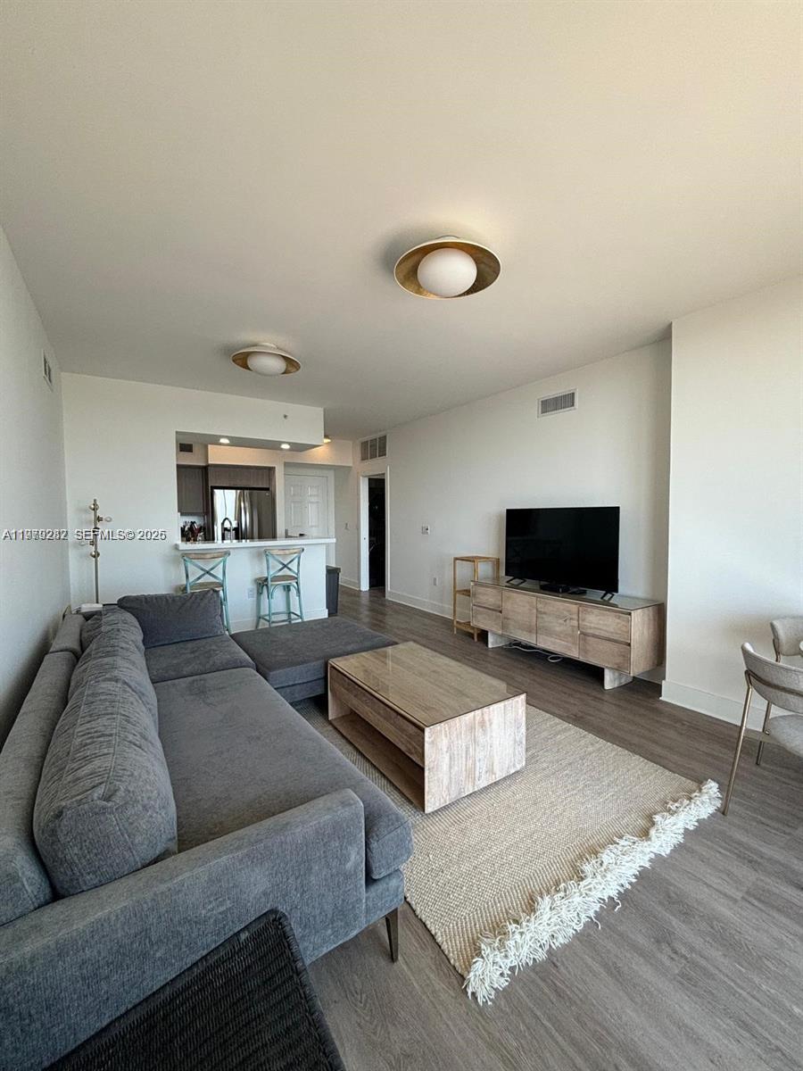 888 Douglas Road, Unit 1002 Coral Gables, FL 33134 - Photo 11 of 34 a living room with furniture and a flat screen tv