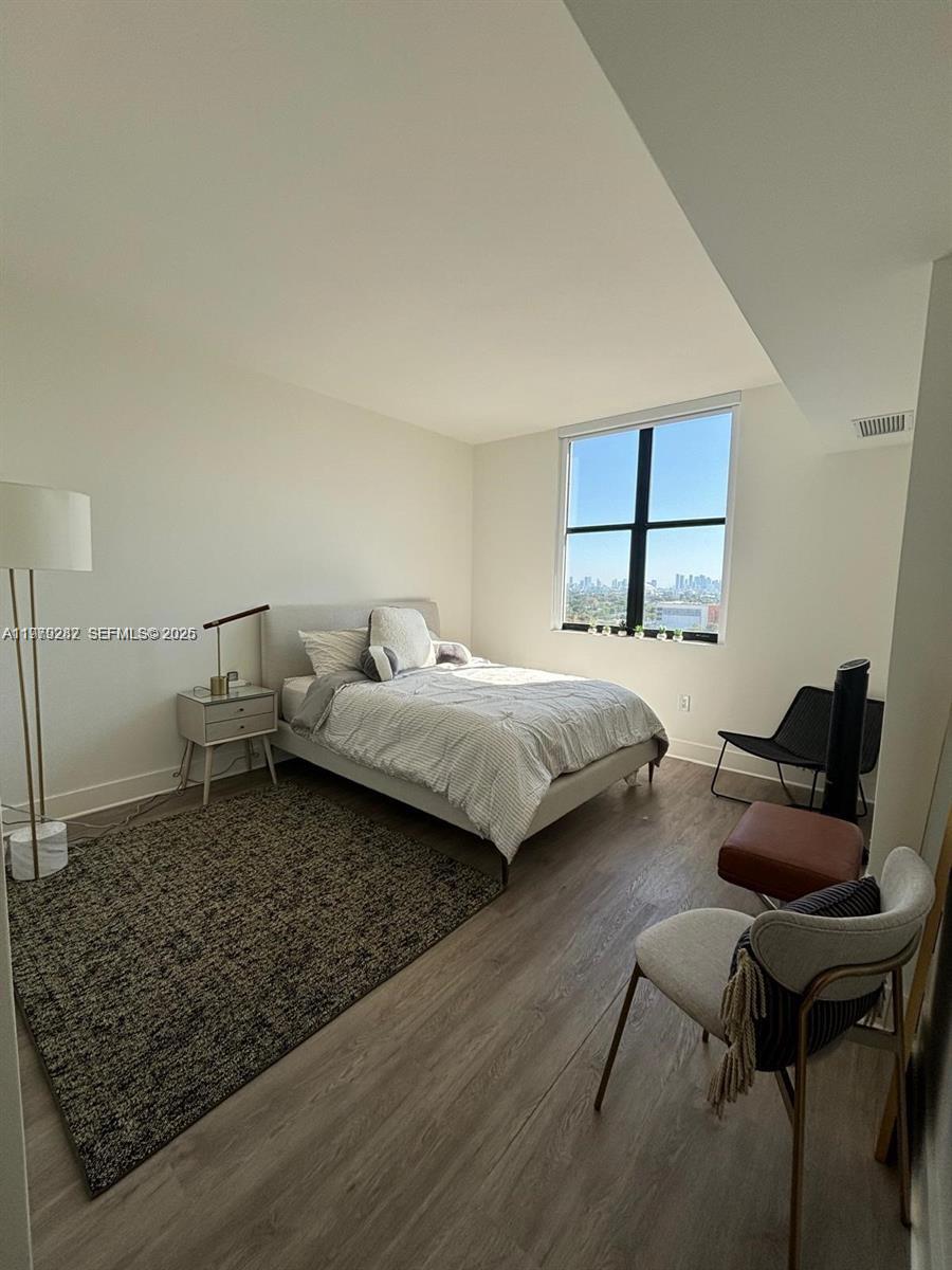 888 Douglas Road, Unit 1002 Coral Gables, FL 33134 - Photo 16 of 34 a bedroom with a bed and a chair