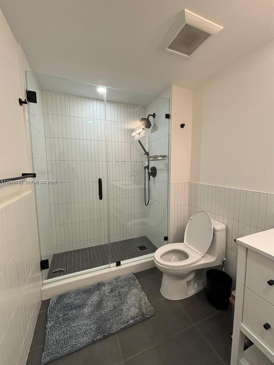 888 Douglas Road, Unit 1002 Coral Gables, FL 33134 - Photo 19 of 34 a bathroom with a toilet and a shower