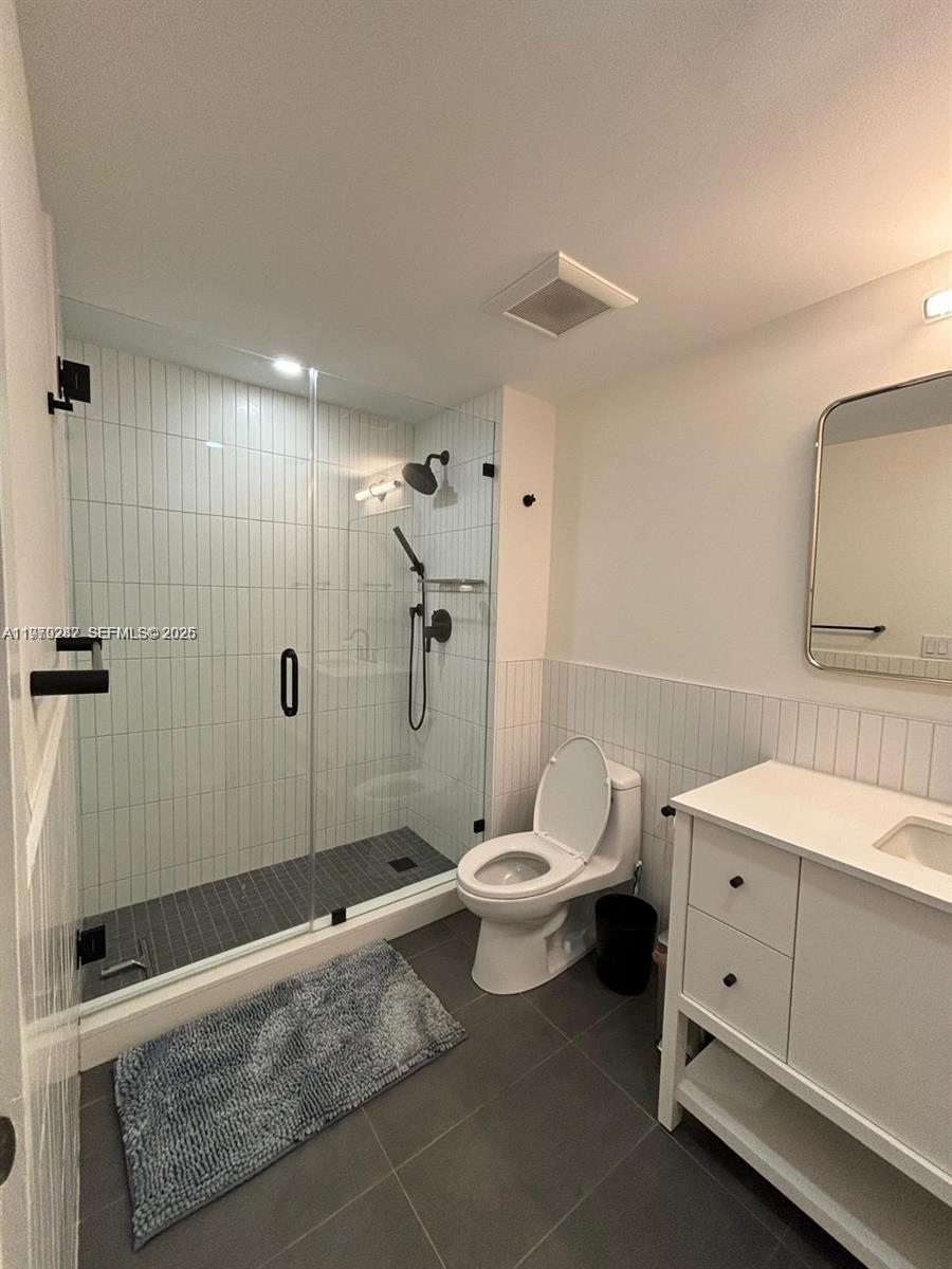 888 Douglas Road, Unit 1002 Coral Gables, FL 33134 - Photo 21 of 34 a bathroom with a toilet sink and shower