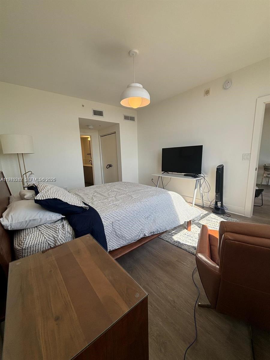 888 Douglas Road, Unit 1002 Coral Gables, FL 33134 - Photo 3 of 34 a bedroom with a bed and a chandelier