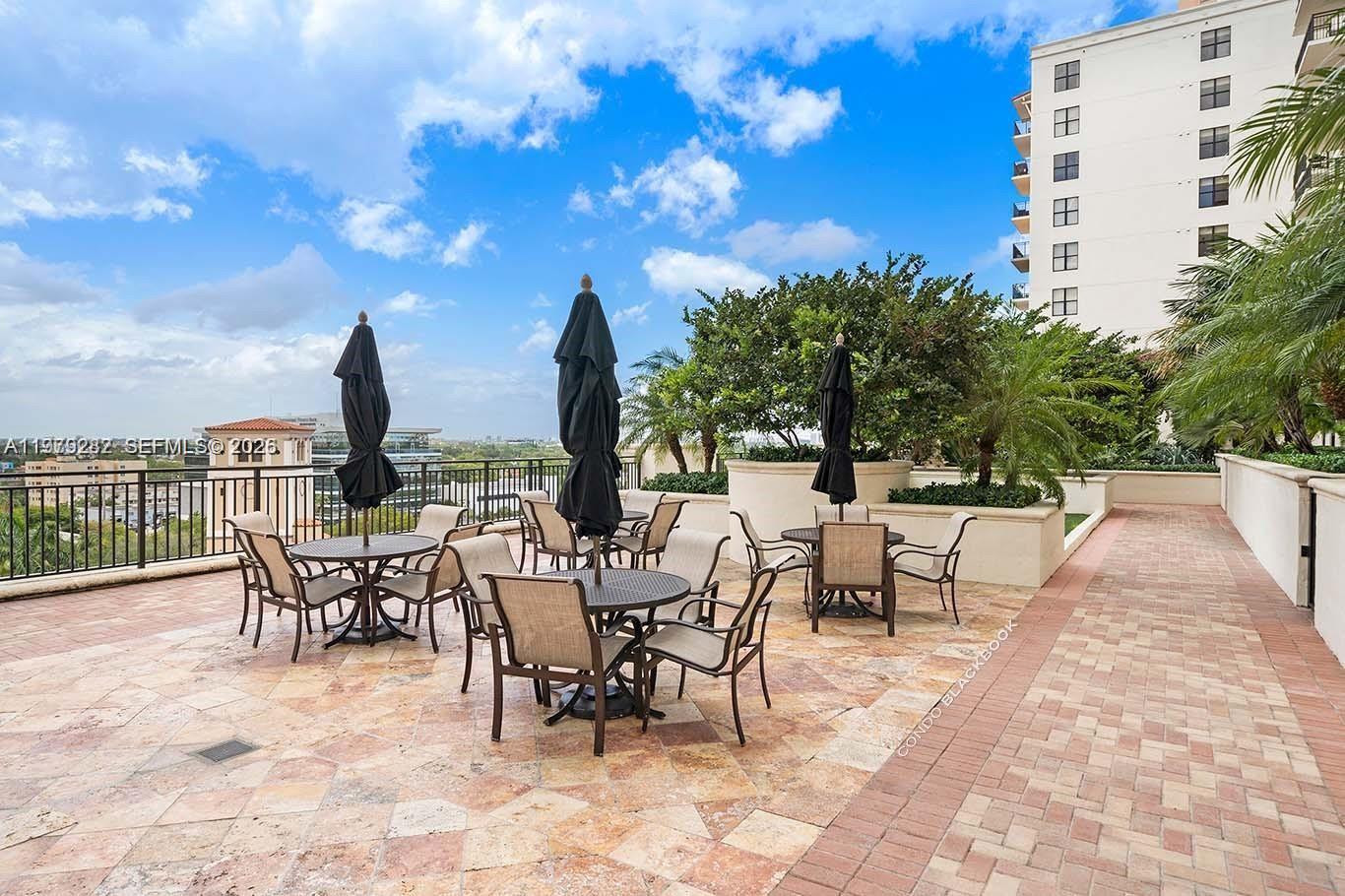 888 Douglas Road, Unit 1002 Coral Gables, FL 33134 - Photo 32 of 34 a view of a patio with a dining table and chairs with wooden floor