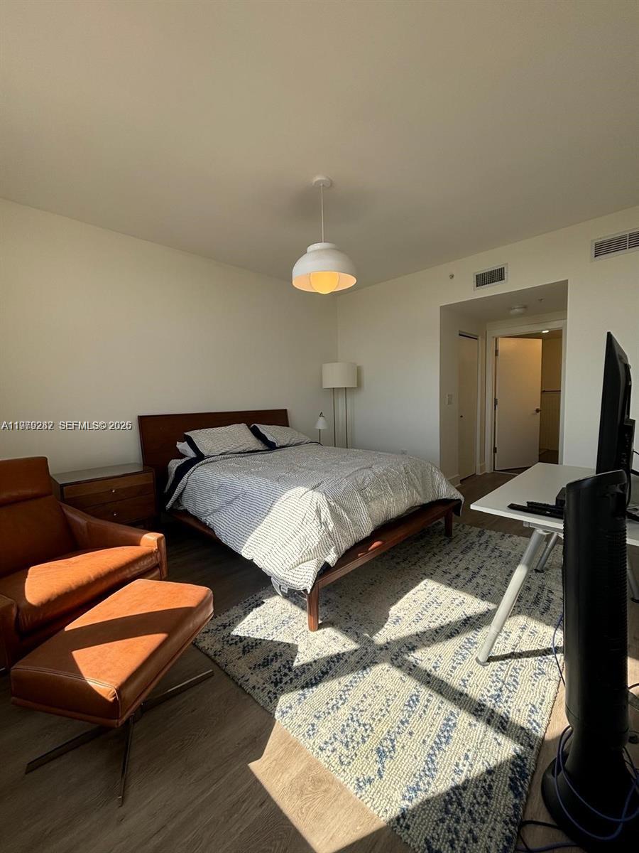 888 Douglas Road, Unit 1002 Coral Gables, FL 33134 - Photo 4 of 34 a bedroom with a bed and a flat screen tv