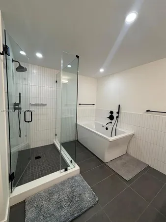 a white bath tub sitting next to a shower