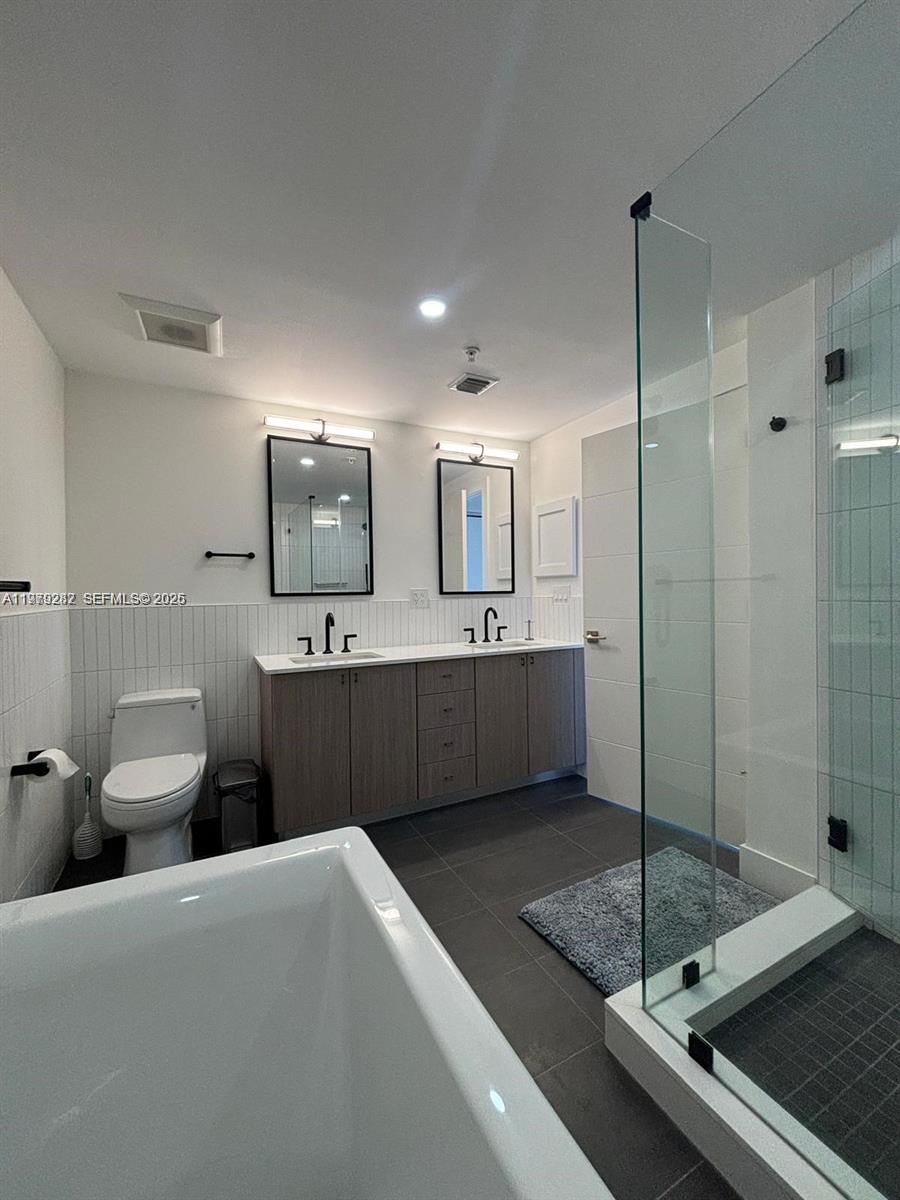 888 Douglas Road, Unit 1002 Coral Gables, FL 33134 - Photo 7 of 34 a spacious bathroom with a sink a mirror and a shower