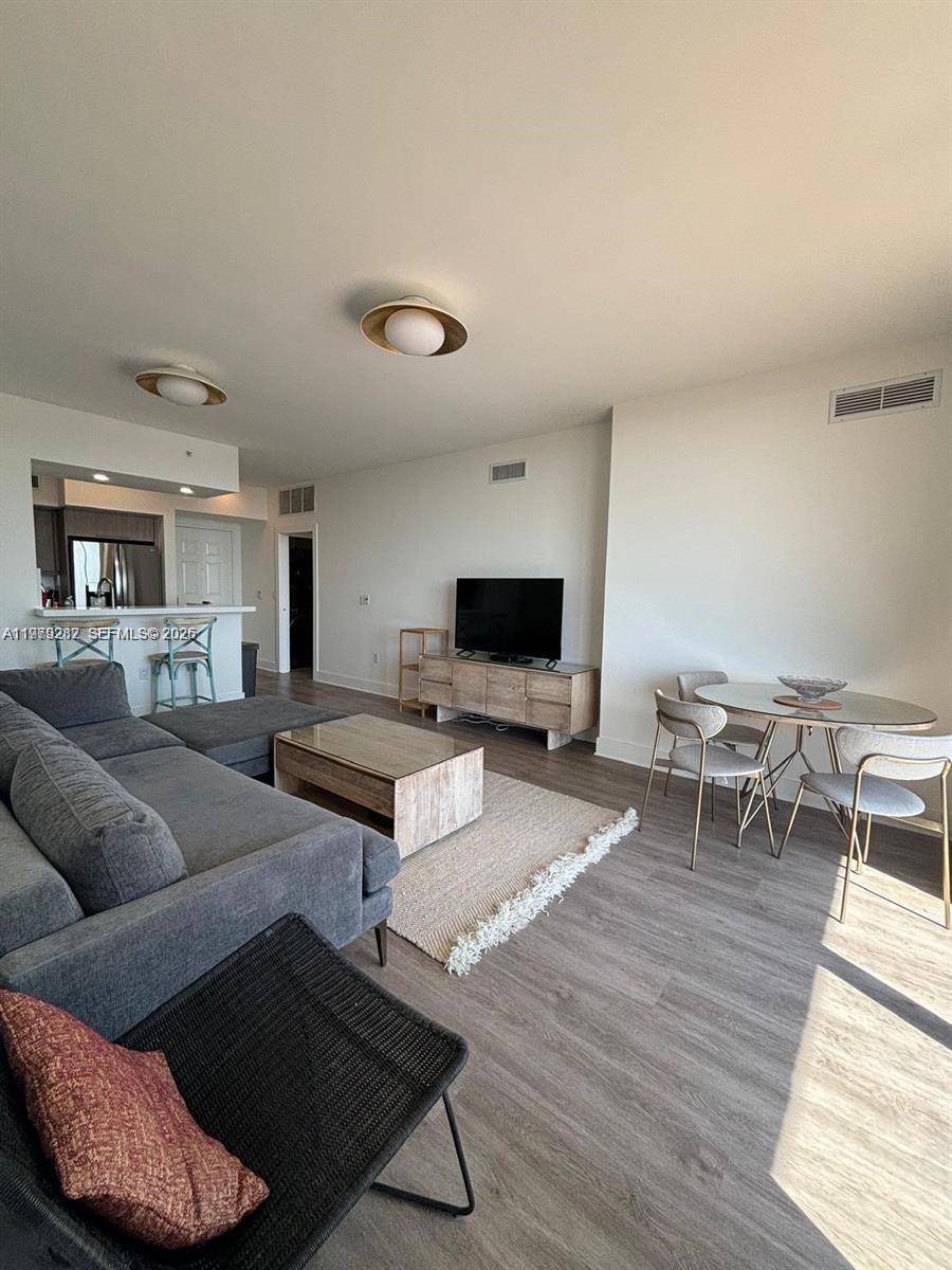 888 Douglas Road, Unit 1002 Coral Gables, FL 33134 - Photo 9 of 34 a living room with furniture and a flat screen tv