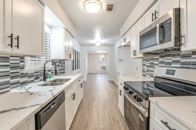 a kitchen with a sink stove top oven and cabinets