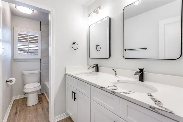 a bathroom with a double vanity sink mirror and toilet