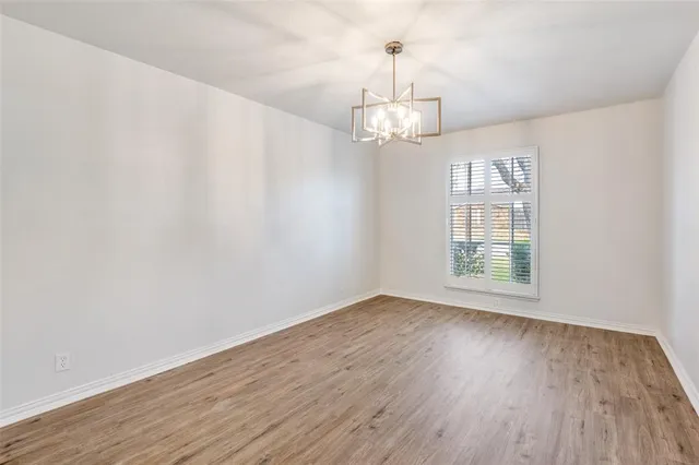 a view of empty room with wooden floor window and fireplace