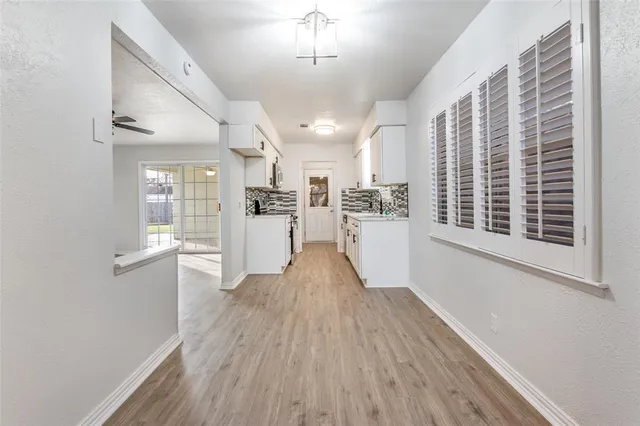 a view of a kitchen with wooden floor and stainless steel appliances