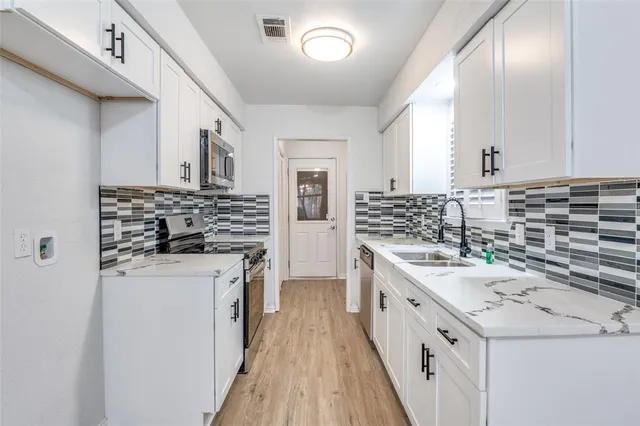 a kitchen with a stove sink and cabinets