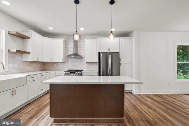 a kitchen with kitchen island a counter space a sink appliances and cabinets