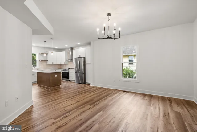 a kitchen with kitchen island granite countertop wooden floors stainless steel appliances and cabinets