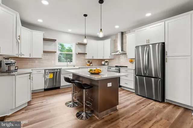a kitchen with a refrigerator a sink and dishwasher with wooden floor