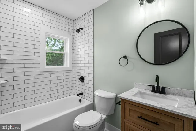 a spacious bathroom with a double vanity sink a mirror and a bathtub