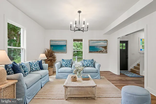 a living room with furniture a chandelier and a window
