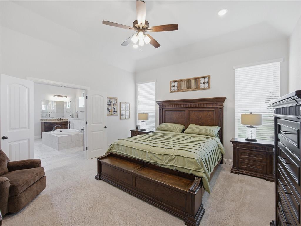150 Quail Ridge Decatur, TX 76234 - Photo 18 of 32 a spacious bedroom with a bed a couch and a chandelier