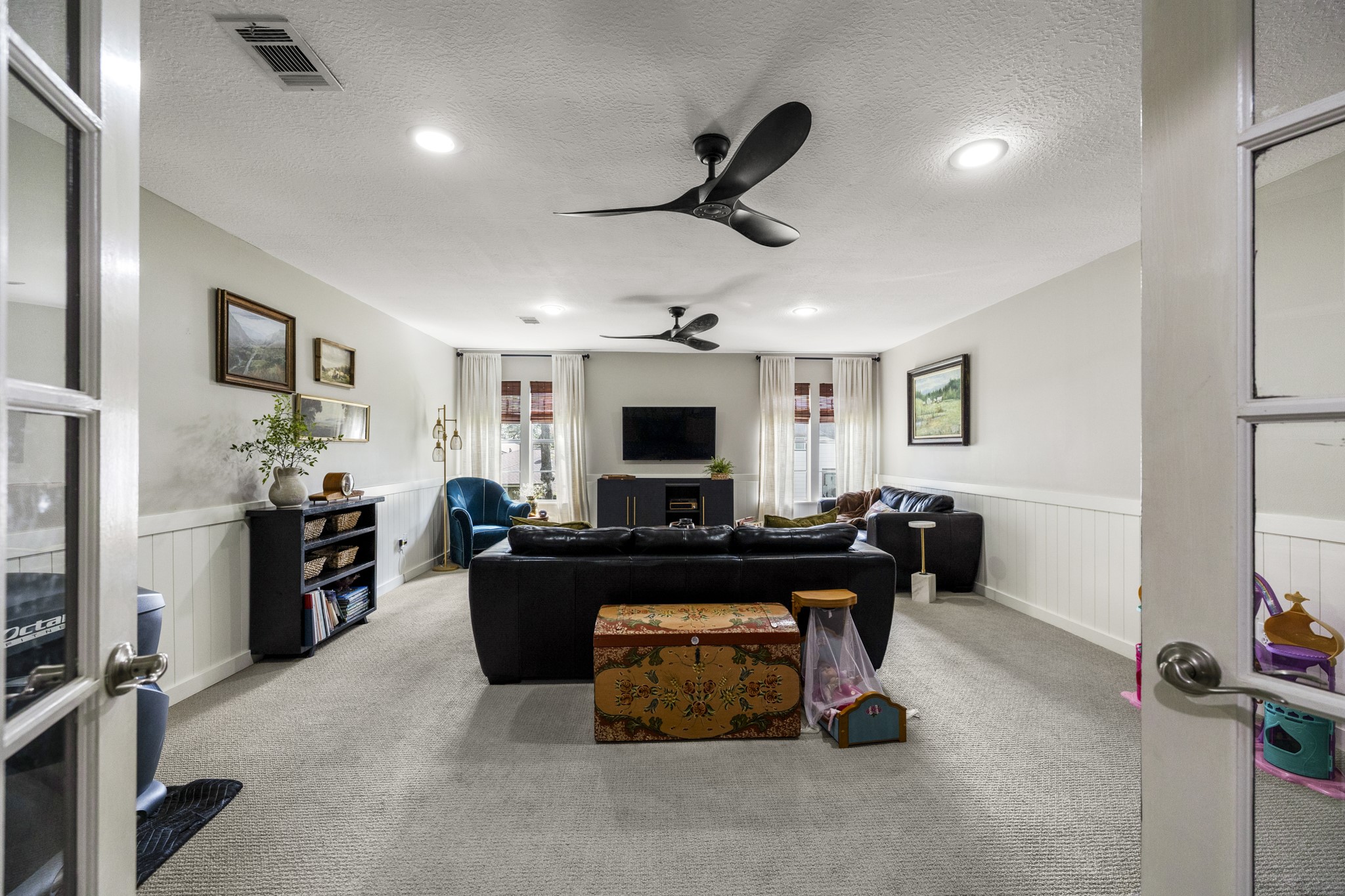 17627 Forest Mist Drive Spring, TX 77379 - Photo 24 of 32 The game room upstairs, located between bedrooms. Accented by wainscotting and windows for lots of light.