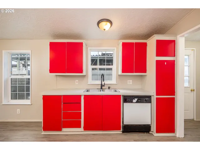a kitchen with red cabinets and window
