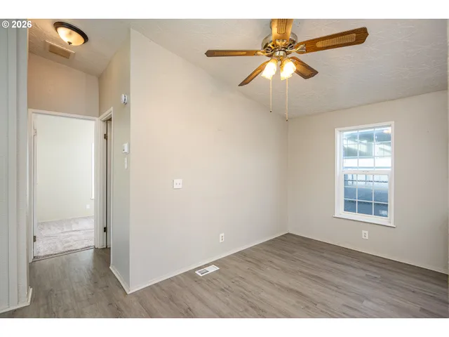 wooden floor in an empty room with a window