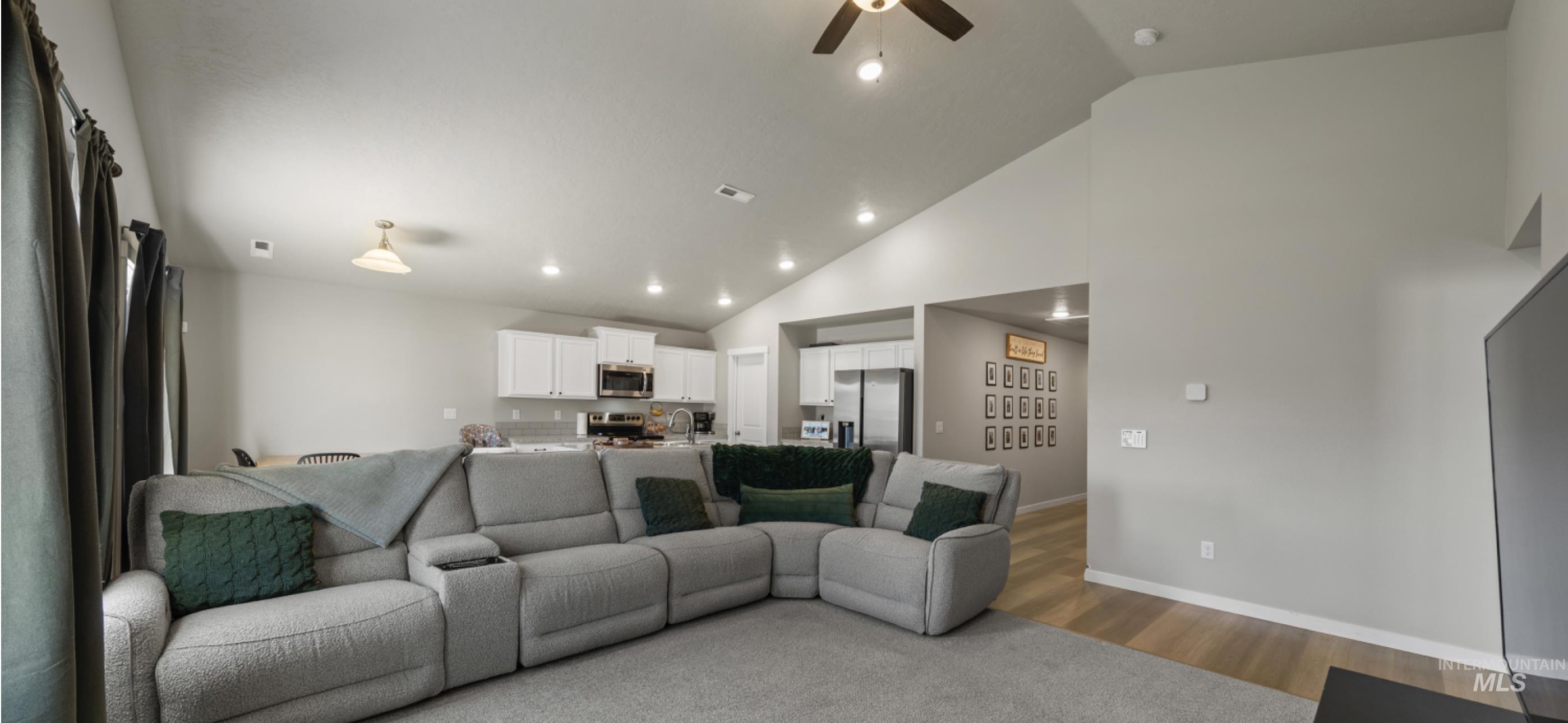 12443 Varga Street Caldwell, ID 83607 - Photo 12 of 27 Living room featuring ceiling fan, wood finished floors, high vaulted ceiling, and recessed lighting
