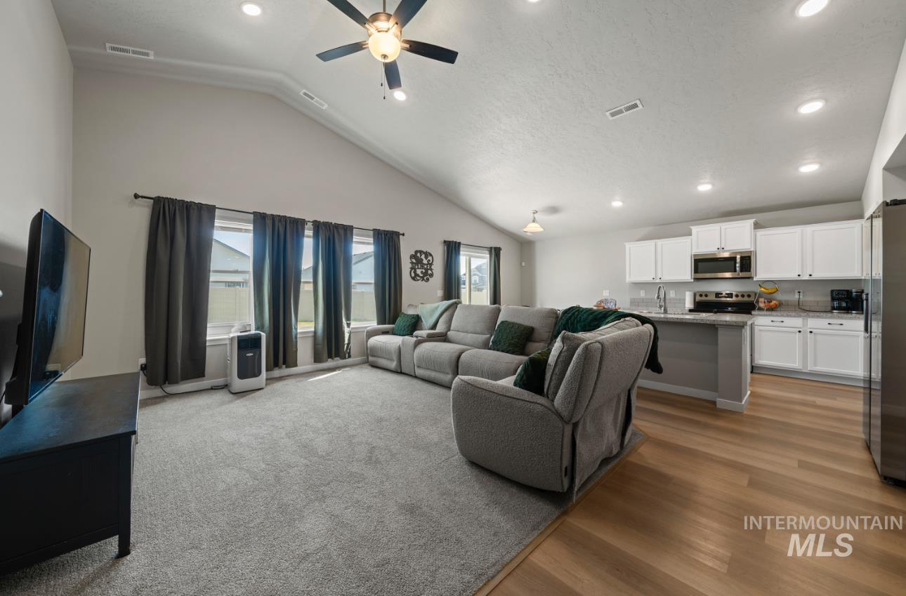 12443 Varga Street Caldwell, ID 83607 - Photo 14 of 27 Living room featuring recessed lighting, a ceiling fan, lofted ceiling, light wood-style floors, and a textured ceiling