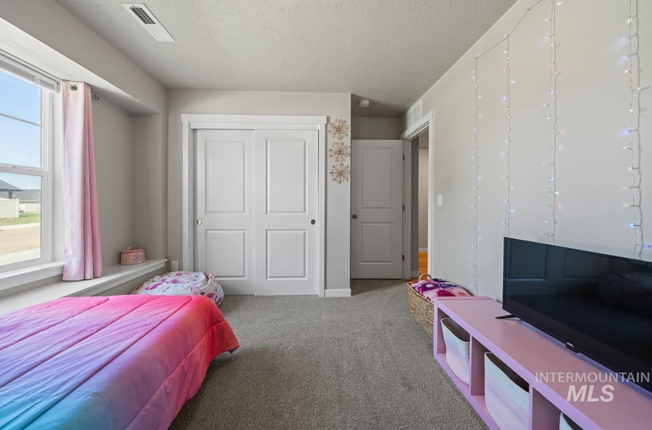 12443 Varga Street Caldwell, ID 83607 - Photo 22 of 27 Carpeted bedroom with a textured ceiling and a closet