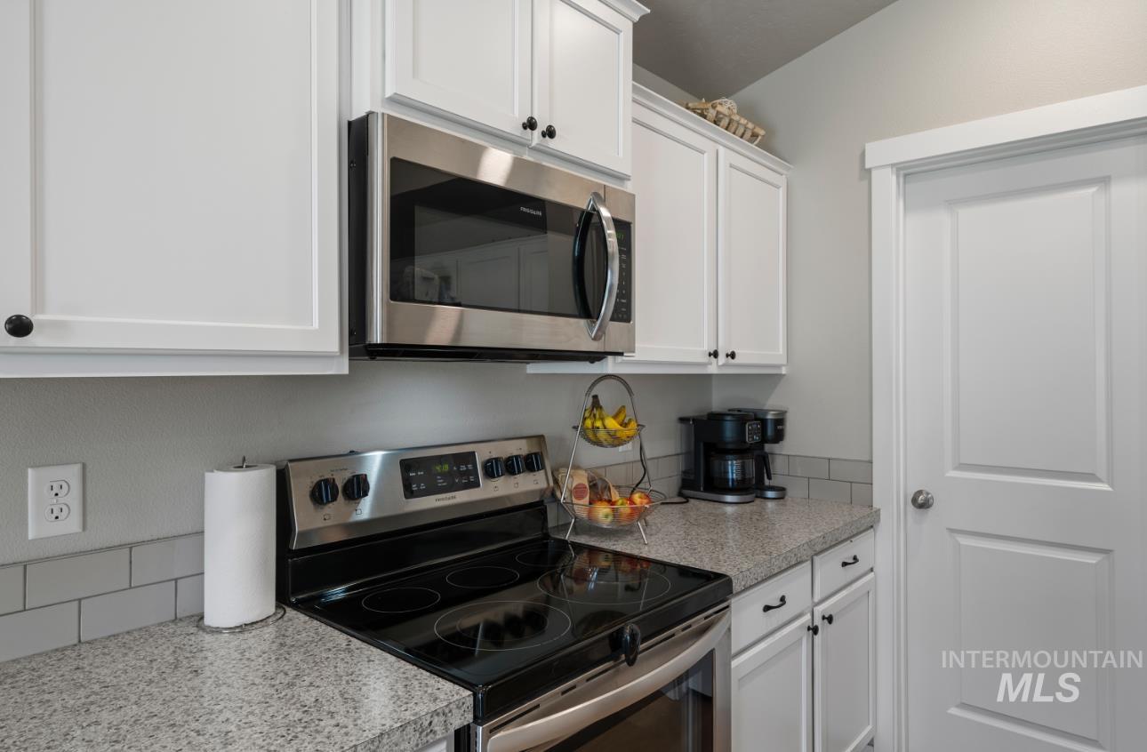 12443 Varga Street Caldwell, ID 83607 - Photo 8 of 27 Kitchen with appliances with stainless steel finishes, white cabinetry, and light countertops