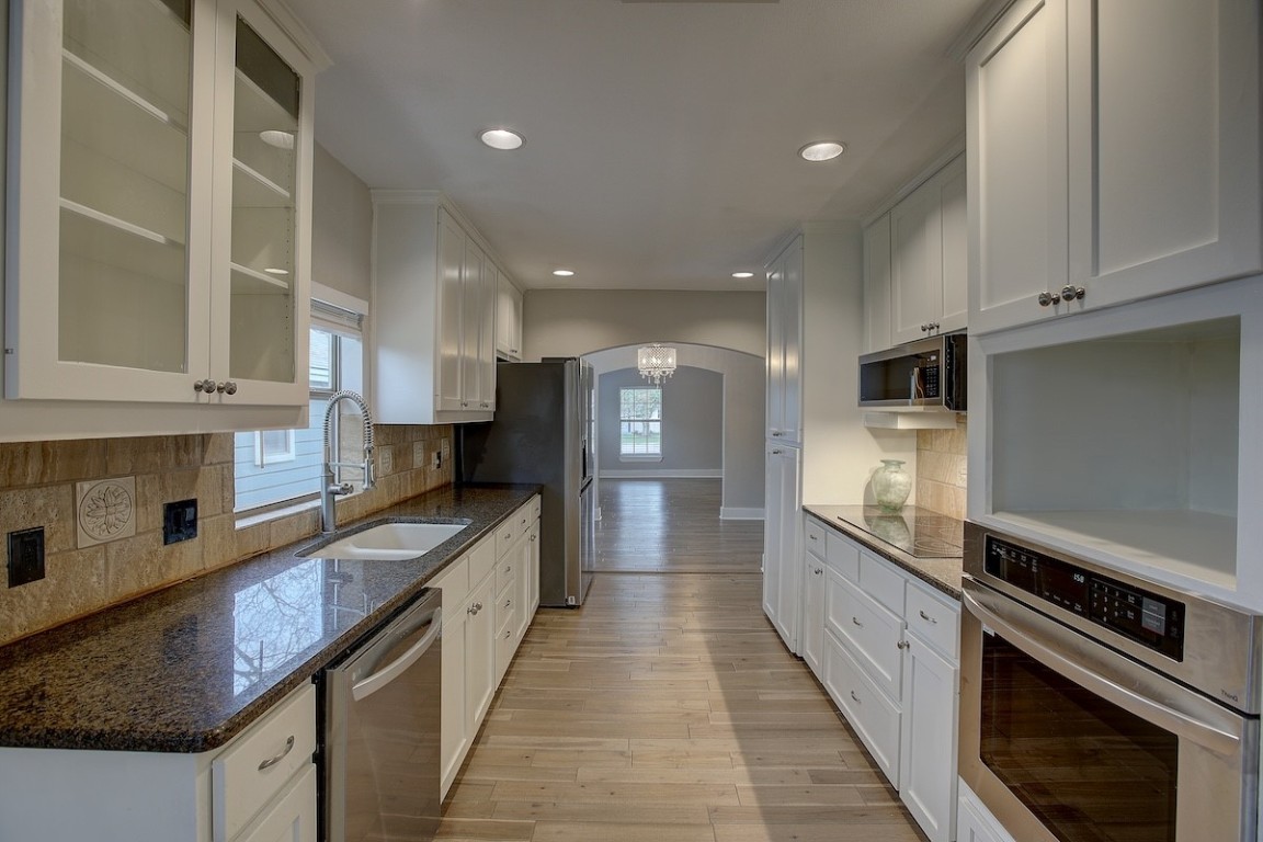 a large kitchen with stainless steel appliances granite countertop a large counter top and a stove top oven