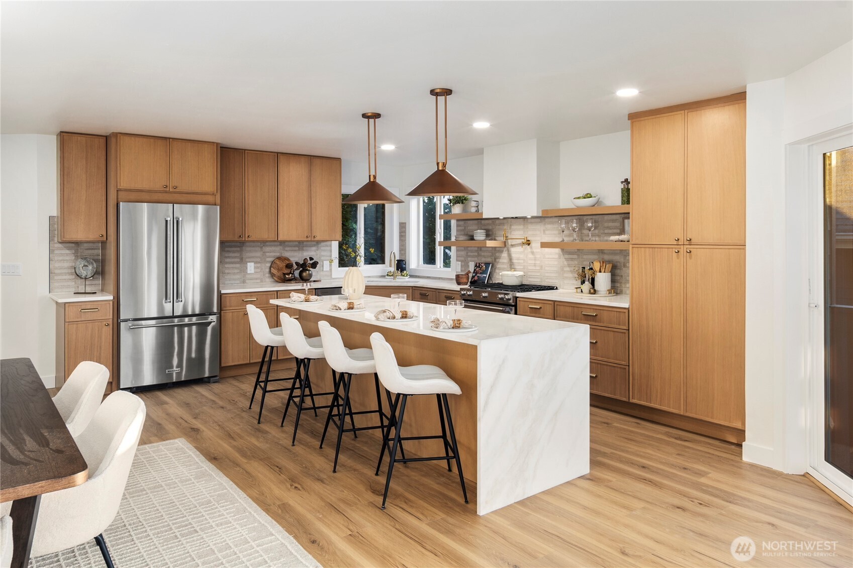 1005 North 33rd Street Renton, WA 98056 - Photo 5 of 36 a kitchen with stainless steel appliances a dining table chairs refrigerator and cabinets