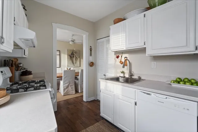 a kitchen with white cabinets and appliances