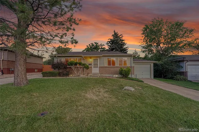 a view of a house with backyard and a tree