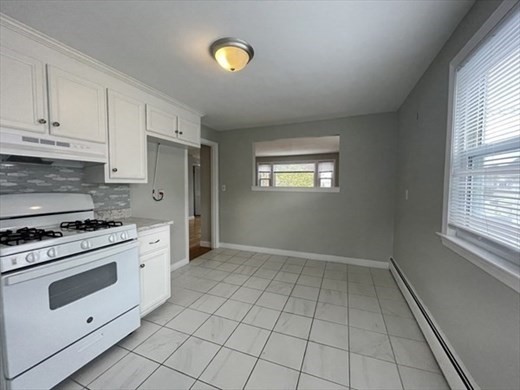 59 Desoto Road, Unit 2 Boston, MA 02132 - Photo 6 of 13 a kitchen with granite countertop a stove a sink and a window