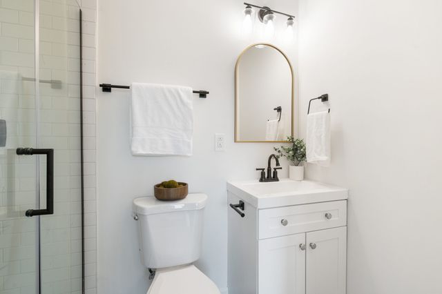 a bathroom with a sink vanity mirror and toilet