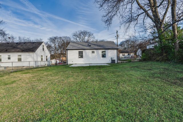 a view of a house with a big yard with large tree