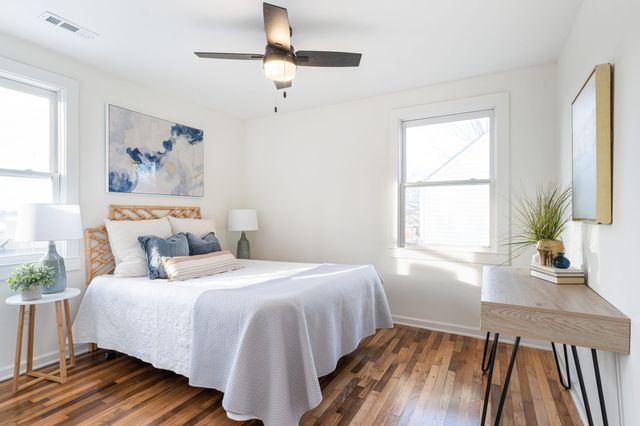 a bedroom with a bed and wooden floor
