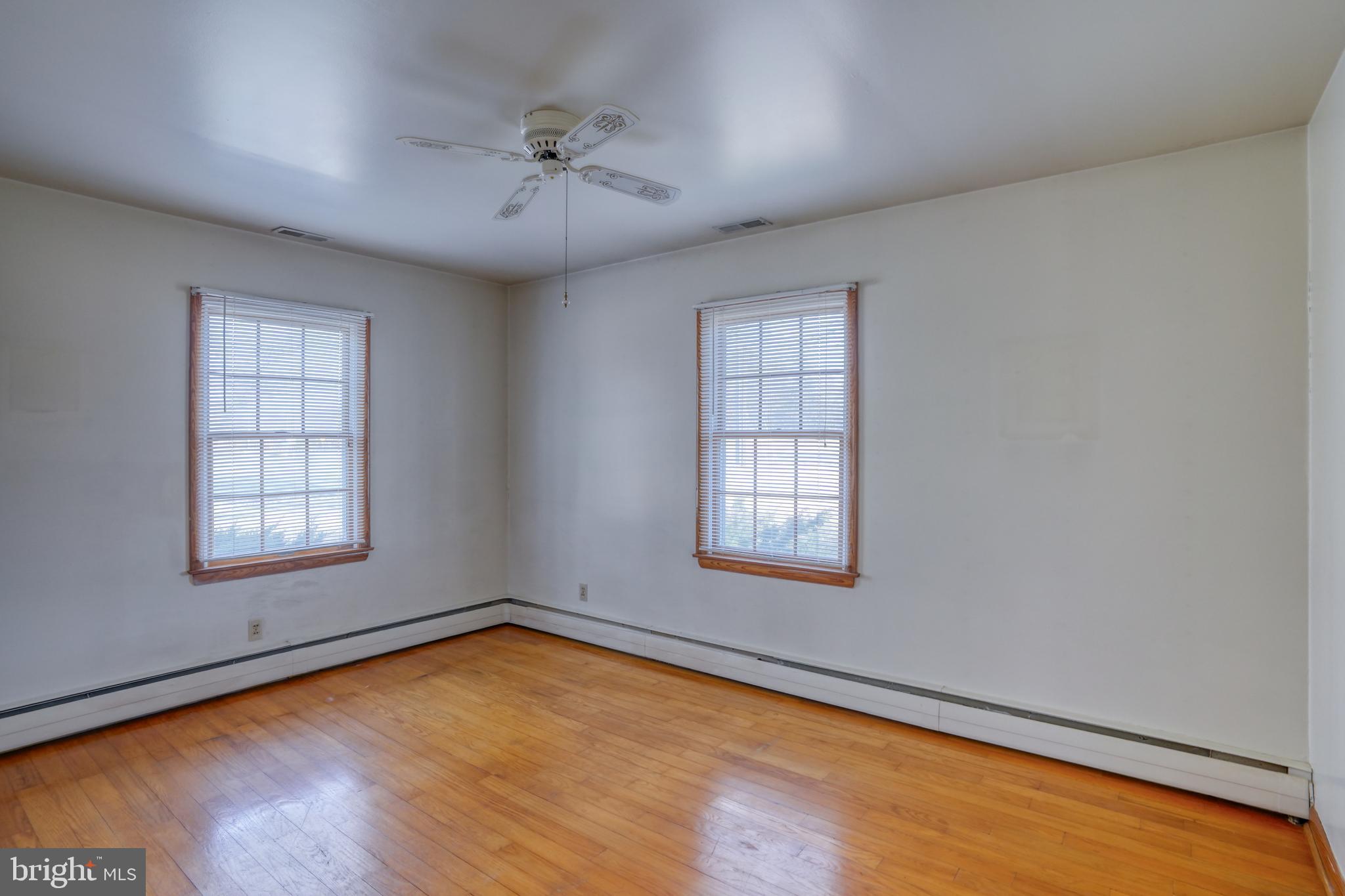4215 Preston Road Hurlock, MD 21643 - Photo 17 of 40 an empty room with wooden floor and windows