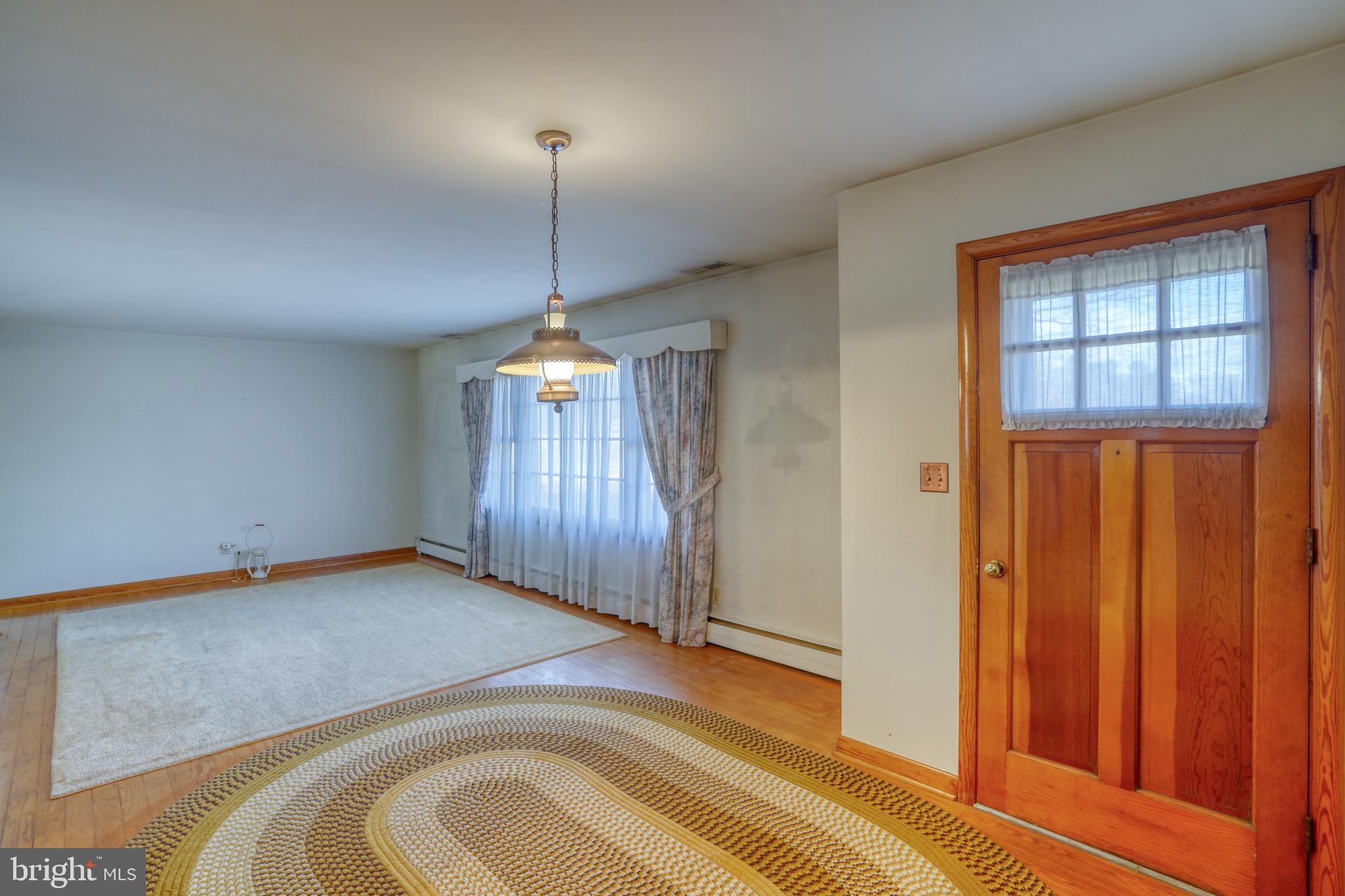 4215 Preston Road Hurlock, MD 21643 - Photo 30 of 40 a view of a livingroom with a chandelier closet and wooden floor