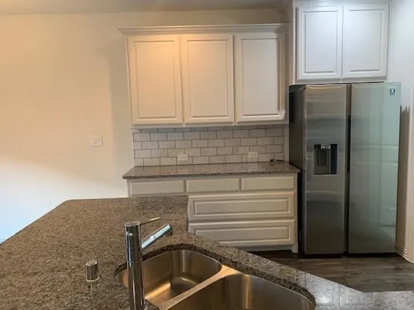 a kitchen with a refrigerator and a sink