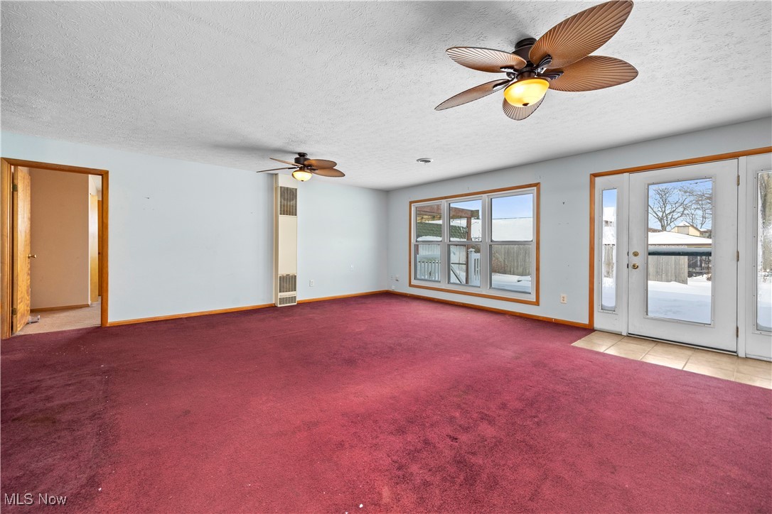 14015 West Lake Road Vermilion, OH 44089 - Photo 23 of 50 Unfurnished room featuring ceiling fan, carpet floors, a textured ceiling, and a heating unit