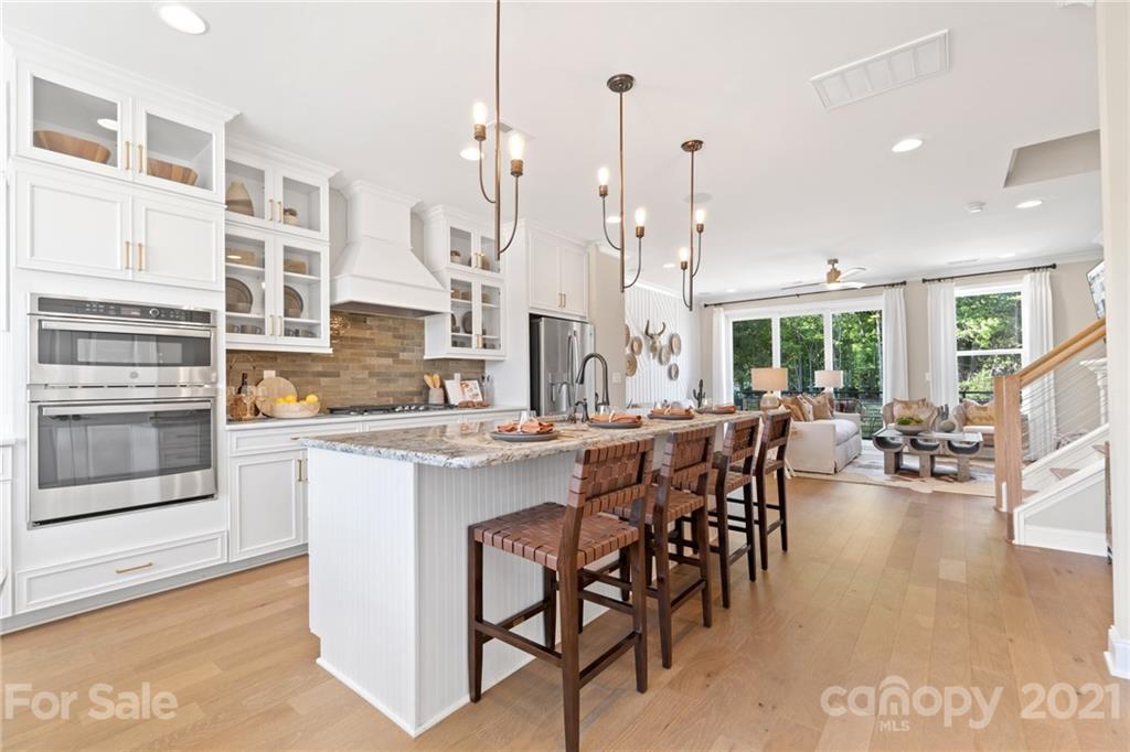 a kitchen with stainless steel appliances kitchen island granite countertop a stove a sink and a refrigerator